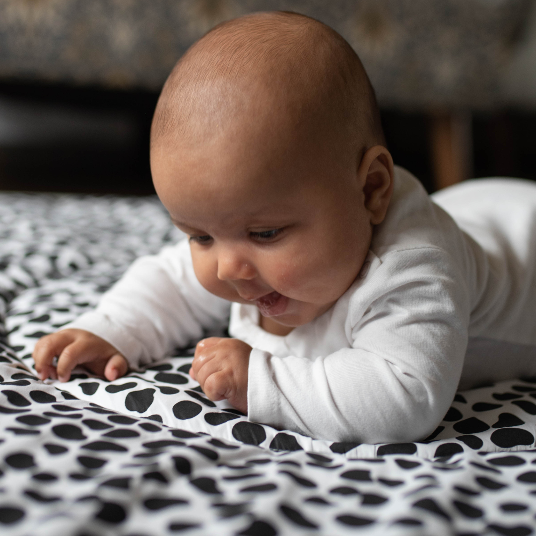 Baby staring at sensory playmat designed by experts in children's visual development